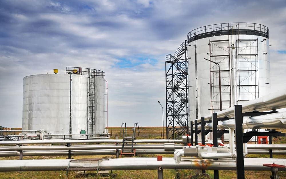 Industrial storage tanks and piping at an energy facility.